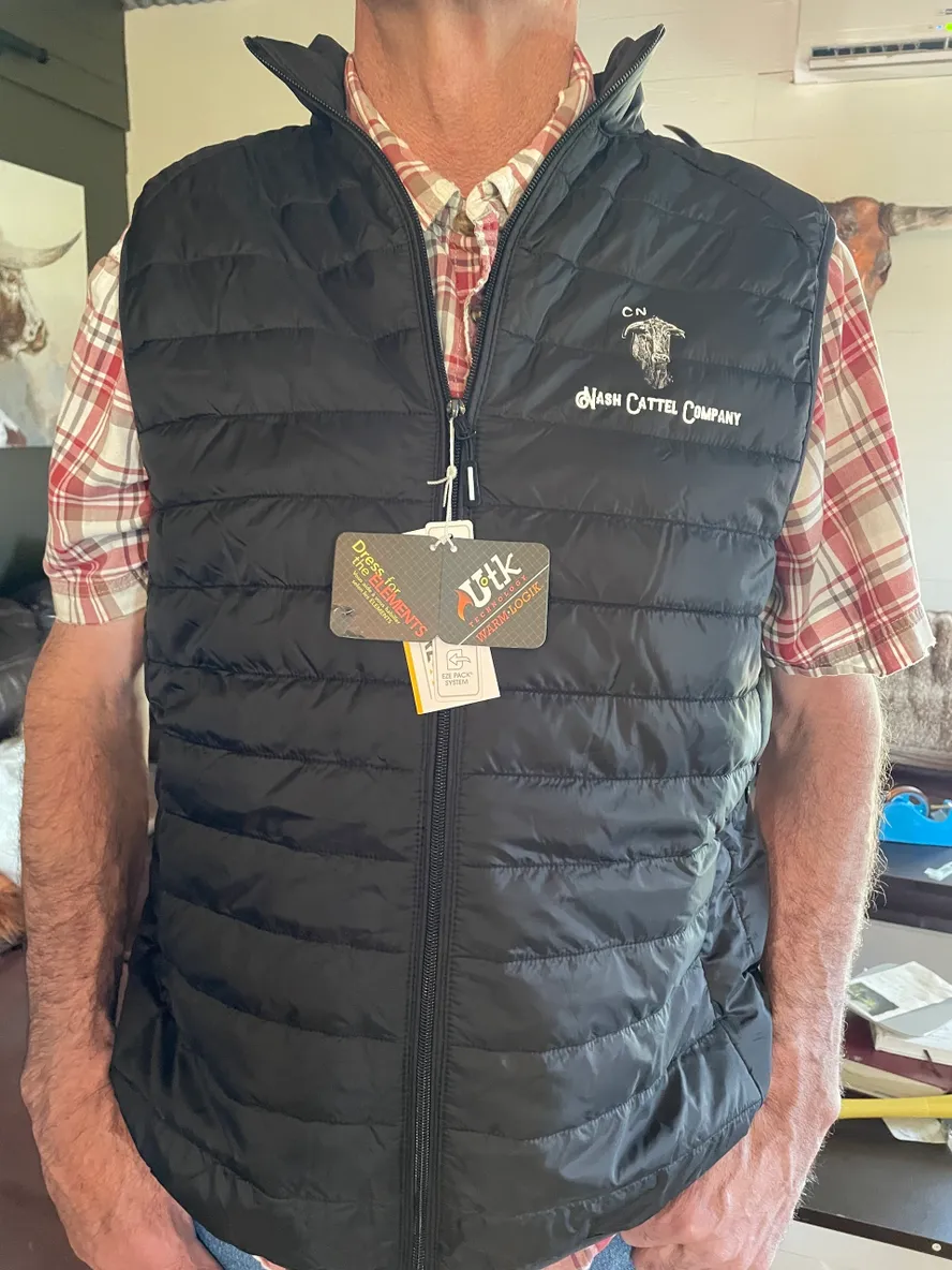 Man wearing black quilted vest indoors.
