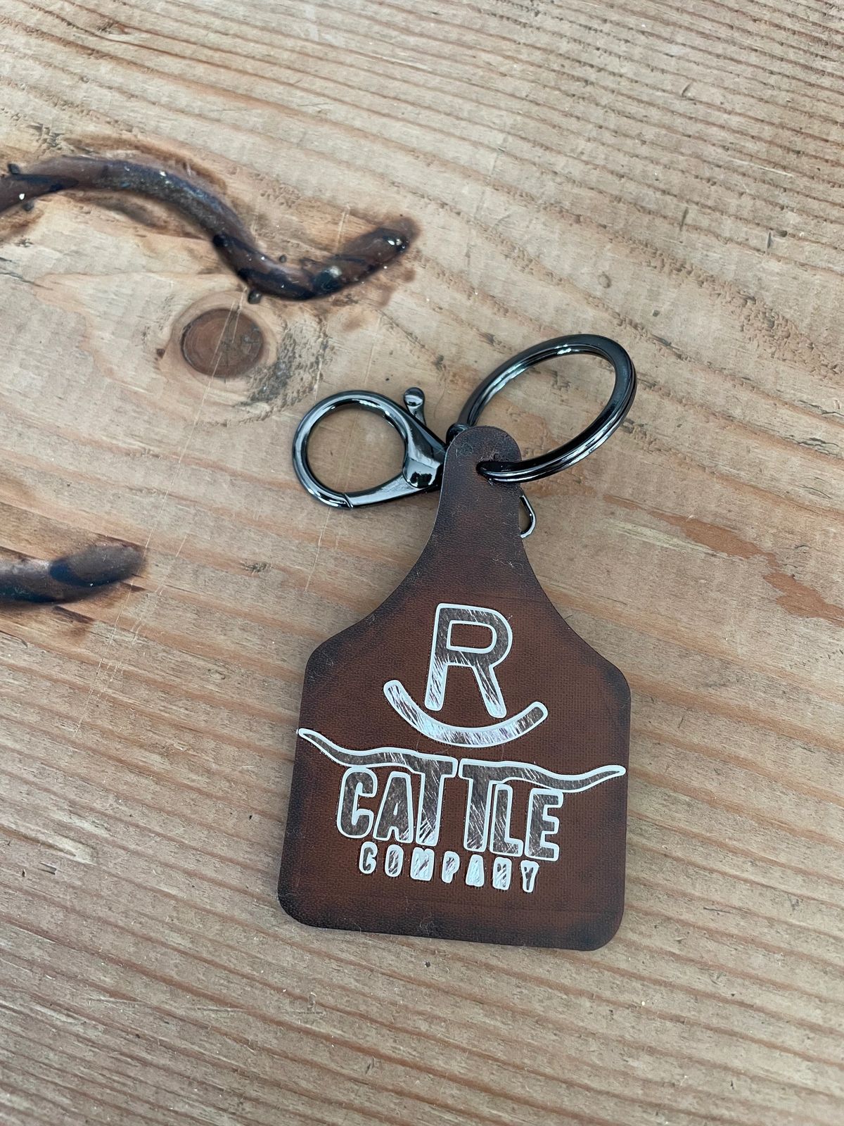 Wooden keychain with "R Cattle Company" logo.