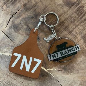 7N7 Ranch keychain on wooden surface.
