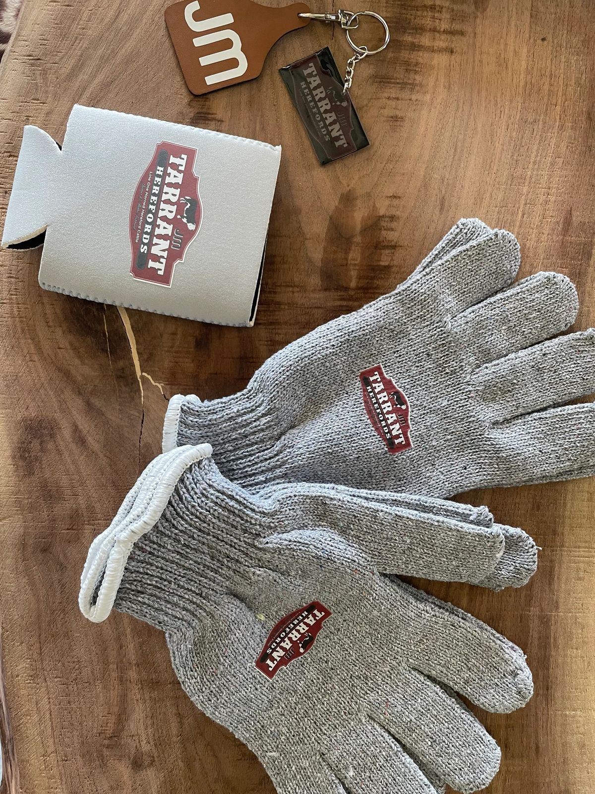 Gray gloves and branded keychain on table.