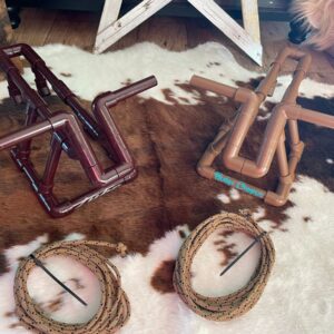 Toy rodeo bulls and lassos on rug.