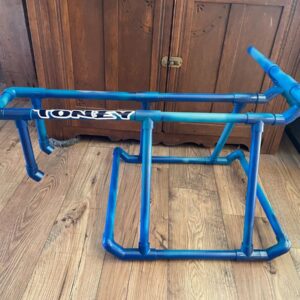 Blue PVC pipe bike frame on floor.